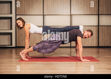 Giovane uomo e donna fare yoga in coppia Foto Stock