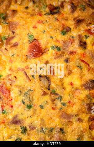 Stile Italiano frittata, uova ricetta pomodori cipolle, i piselli e i peperoni in capsula di vetro Foto Stock
