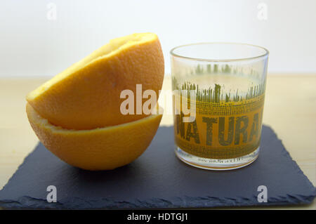 Un bicchiere di succo di arancia con arance intorno a. Foto Stock