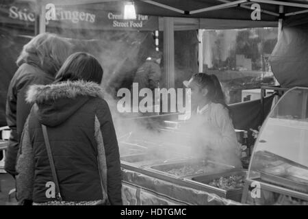 Giovane bella donna tailandese che serve cibo di strada in un mercato in stallo palmerston road southsea England Regno Unito Foto Stock