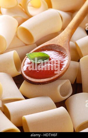 Paccheri, napoletana tradizionale pasta e salsa di pomodoro in un cucchiaio di legno Foto Stock