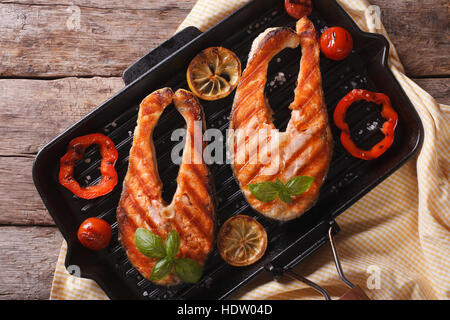 Filetti di salmone e verdure grigliate in una padella di close-up. vista orizzontale dal di sopra Foto Stock