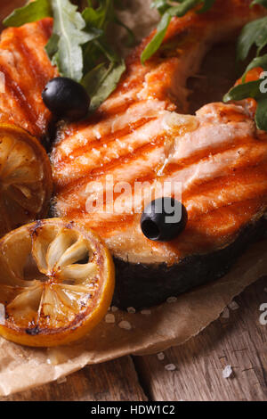 Salmone alla griglia bistecca e verdure macro su carta. verticale, stile rustico Foto Stock