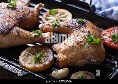 Due grigliate di cosce di pollo e verdure in padella per grigliare macro. orizzontale Foto Stock