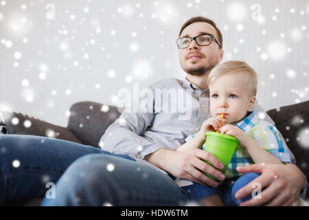 Padre e figlio di bere dal bicchiere a casa Foto Stock