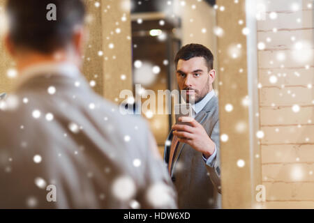 Uomo in tuta prendendo selfie specchio al negozio di abbigliamento Foto Stock