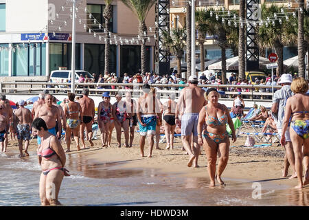 Spiaggia affollata scena con principalmente donne e uomini anziani, rilassanti passeggiate o esercitando sul litorale Foto Stock