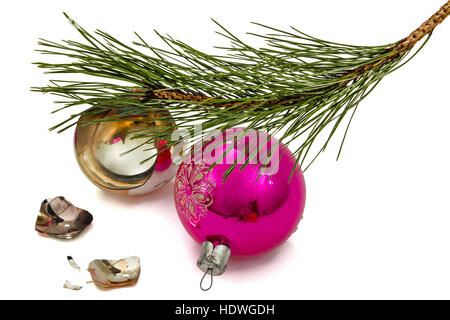 Rotture di palla di Natale si trova al disotto del ramo del pino, isolato su sfondo bianco Foto Stock