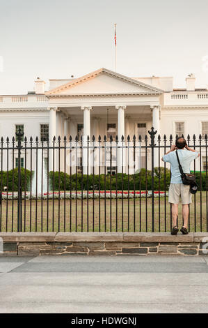 Washington, DC - un picchi turistici attraverso la Casa Bianca cortile anteriore recinto cercando di ottenere un angolo di chiara a fotografare. Foto Stock