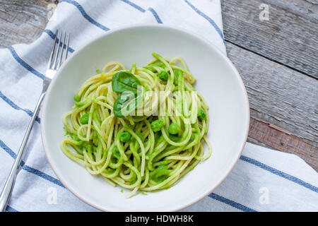 Pasta verde con pesto e piselli. Amore per un sano cibo crudo concetto. Foto Stock