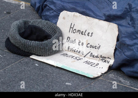 Senzatetto senzatetto sonno agitato mendicare mendicante affamato di accattonaggio freddo inverno triste donazione denaro barbone hobo poveri povertà disperazione più bisognosi della città di crisi Foto Stock