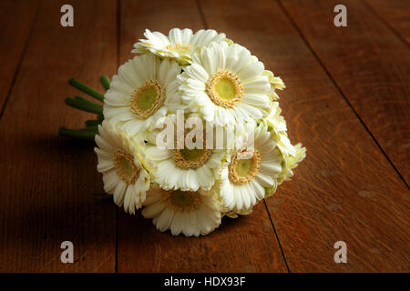 La crema di gerbera bouquet di nozze su un pavimento di legno di quercia. Foto Stock