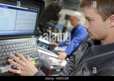 Meccanico automatico insegnante e partecipante di eseguire prove a scuola meccanico Foto Stock