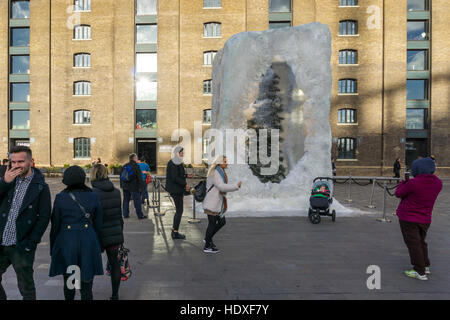 La gente a prendere le fotografie di fronte a combattere il fuoco con il gelato, un albero di Natale racchiusi in un blocco di ghiaccio, di Alex Chinneck. Foto Stock