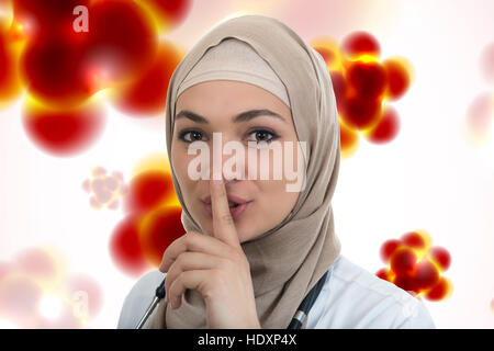 Ritratto di gentile, musulmana con il hijab medico mostrando shh sospiro, silenzio. Foto Stock