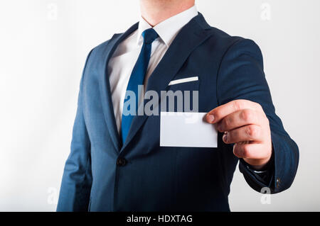 Imprenditore della tuta è che mostra business card su sfondo bianco Foto Stock