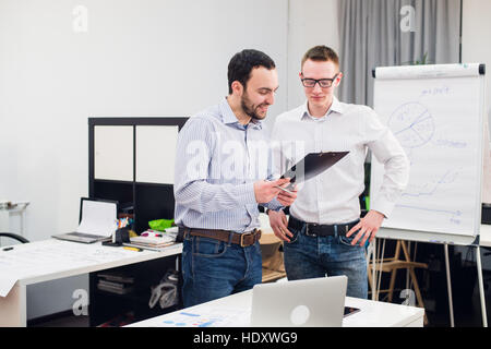 Due allegro webdesigners standing in ufficio Foto Stock