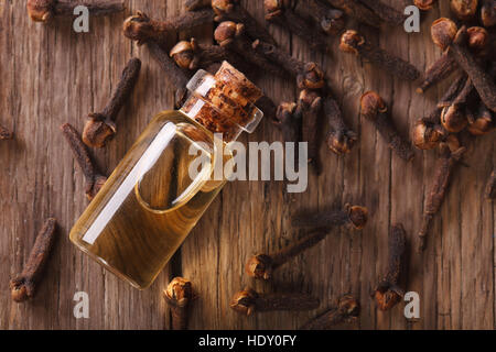 Olio di chiodi di garofano in bottiglia vicino sul tavolo. vista orizzontale dal di sopra Foto Stock