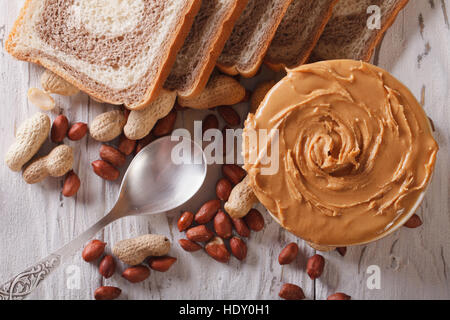 Burro di arachidi e il pane sulla tavola di close-up. vista orizzontale dal di sopra Foto Stock