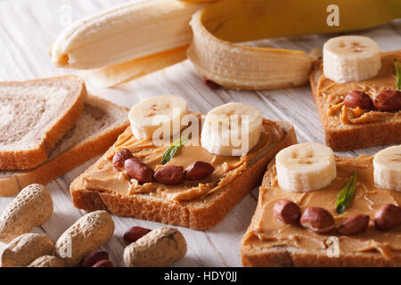 Funny panini con burro di arachidi e banana sul tavolo orizzontale. Foto Stock