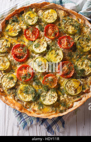 Sformatino rustico con formaggio, pomodori e zucchine closeup. verticale vista superiore Foto Stock