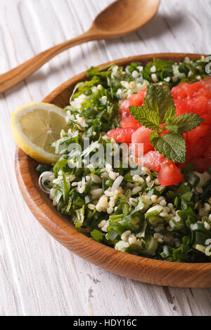 Dietetici tabulé orientale closeup insalata in una ciotola di legno verticale. Foto Stock