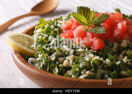 Classica insalata tabulé macro in una ciotola di legno orizzontale. Foto Stock