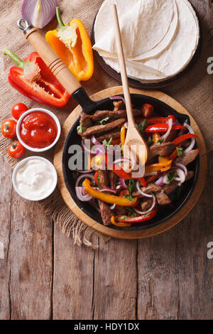 Le fajitas messicane su un tavolo in stile rustico. Verticale di close-up vista da sopra Foto Stock