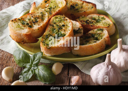 Pane con basilico e aglio close-up su una piastra orizzontale di stile rustico Foto Stock