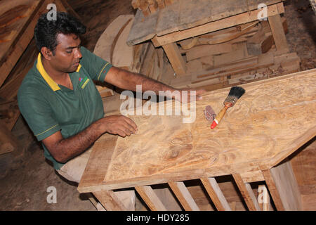Il governo dello Sri Lanka di levigatura falegname giù una porta di legno incisa Foto Stock