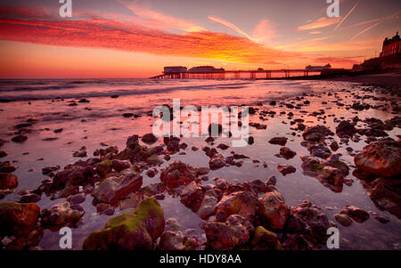 Sunrise over Cromer Pier, casa del Cromer scialuppa di salvataggio Station e il Pavilion Theatre, sulla costa di Norfolk Foto Stock