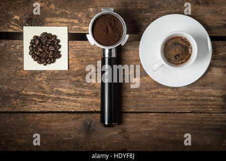 Caffè in grani, macinato e tazzina di caffè sul tavolo di legno, piana, laici cafe concept Foto Stock