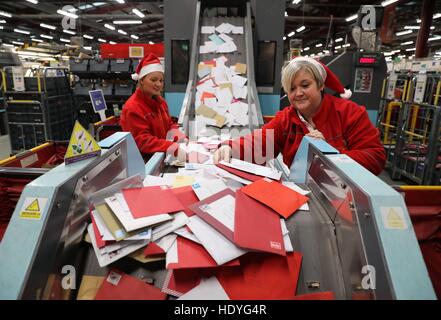 Royal Mail lavoratori Paula Carey(L) e Joanna Murray smistamento della posta presso la Royal Mail ufficio di smistamento in Turner Road, Glasgow, dove ai lavoratori del settore postale è in grado di gestire alcuni tra i milioni di invii di posta di Natale su ciò che ci si aspetta di essere uno di loro giorno più trafficato dell'anno. Foto Stock