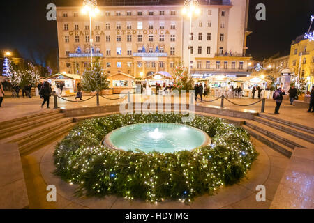 Il tempo di avvento nel centro della città di Zagreb, Croazia. Corona di avvento intorno alla fontana acqua Mandusevac sulla centrale Piazza Jelacic. Foto Stock