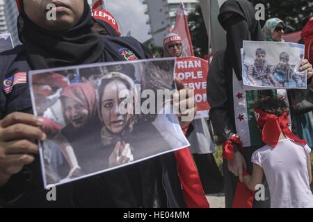 Kuala Lumpur, Malesia. Xvi Dec, 2016. Una ragazza Siriana (R) che vive in Malaysia tenere la madre durante una manifestazione di protesta contro il bombardamento di Aleppo in Siria, davanti all'Ambasciata russa di Kuala Lumpur, Malesia, 16 dicembre 2016. I residenti di Aleppo sono state sotto assedio per settimane e hanno subito il bombardamento, insieme con il cibo cronica e la penuria di carburante a causa dei combattimenti tra le forze governative e i loro alleati e governo anti-combattenti.ZUMAPRESS/ KAMEN © Kamen/ZUMA filo/Alamy Live News Foto Stock