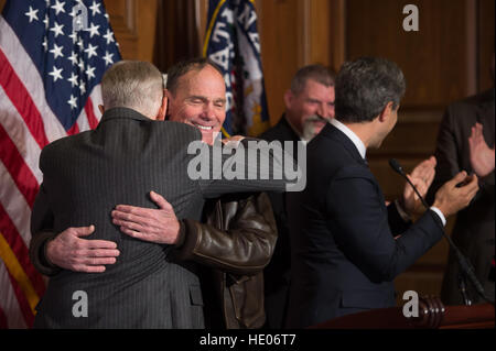 Washington, Stati Uniti d'America. 15 Dic, 2016. Artista contemporaneo Michael Heizer, centro abbraccia Senato leader della minoranza Harry Reid durante una servitù cerimonia di firma negli Stati Uniti Capitol Dicembre 15, 2016 a Washington, DC. La servitù aiuterà a proteggere il bacino e la gamma Monumento Nazionale in Nevada che contiene i massicci lavori di sterro arte progetto Città da Heizer. © Planetpix/Alamy Live News Foto Stock