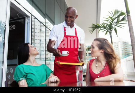 Felice African American cameriere a lavorare in un ristorante con gli ospiti Foto Stock