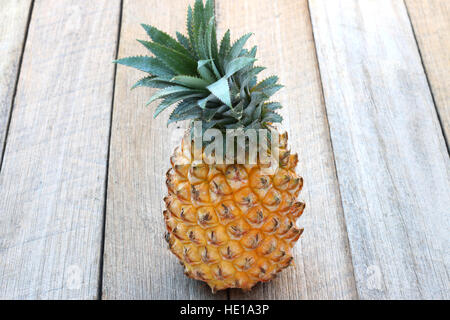 Close up di ananas intero isolato sul pannello di legno Foto Stock