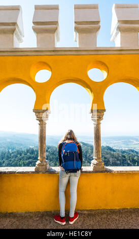 Giovane donna guardando attraverso il paesaggio dalla pena Palace, il Palácio Nacional da Pena, Sintra, Portogallo Foto Stock