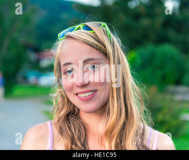 Giovane donna con occhiali da sole sulla testa, sorridente, Schliersee, Alta Baviera, Baviera, Germania Foto Stock