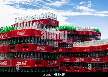 Svuotare la Coca Cola bottiglie in casse sono di accatastamento Foto Stock