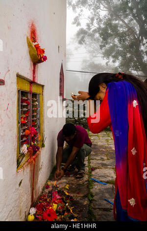 Una donna sta pregando per le statue di divinità al di fuori del tempio khadga devi mandir presso il festival indù, darsain Foto Stock