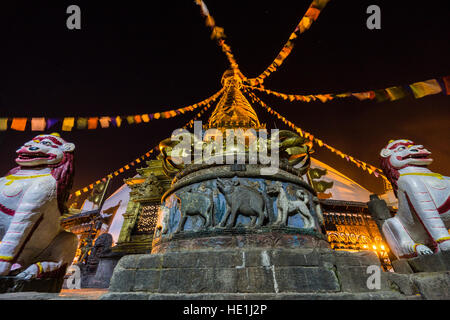 Il bianco stupa di swayambhunath temple, Monkey Temple, è decorata con la preghiera tibetano bandiere e illuminata di notte Foto Stock