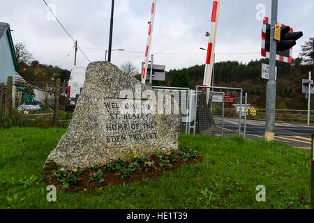 Grande pietra intagliata all'ingresso St Blazey, Par, Cornwall, Regno Unito. Passaggio a livello featured in background. Foto Stock