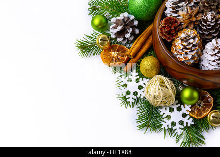 Natale decorato pigne nella ciotola di legno con rami di abete. Auguri di Natale sfondo con bastoncini di cannella ed essiccato fettine di arancia. Copia spac Foto Stock