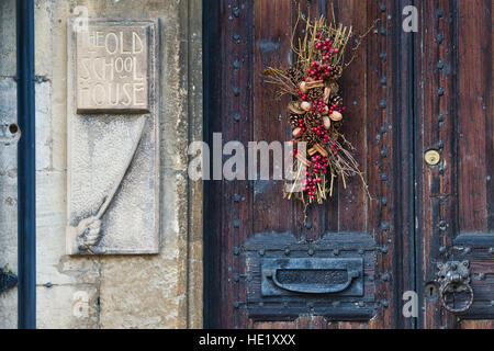 Ghirlanda di Natale su old school house. Chipping Campden, Cotswolds, Gloucestershire, Inghilterra Foto Stock