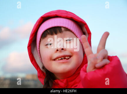 Giovane ragazza sorridente sullo sfondo del cielo blu Foto Stock