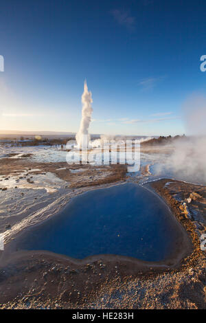 Blesi, hot spring pool e Geyser Strokkur, fontana geyser nell'area geotermale accanto al fiume Hvítá, Haukadalur, Sudurland, Islanda Foto Stock