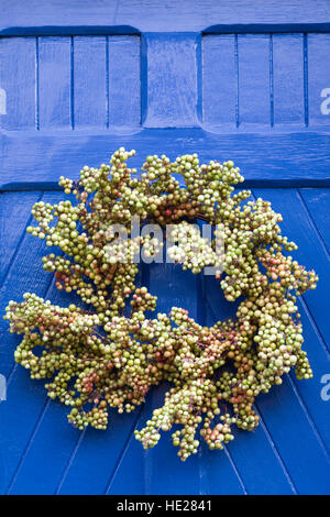 Decorativa ghirlanda di Natale appeso ad un portone blu. Foto Stock