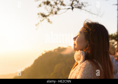 Closeup donna faccia sensazione di fresco con il sorgere del sole al mattino Foto Stock